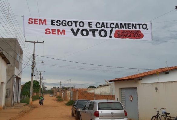 Após retirada de faixa de protesto do bairro Beira Rio, moradores colocam outra no lugar e reafirmam: “sem esgoto e calçamento, sem voto” 	